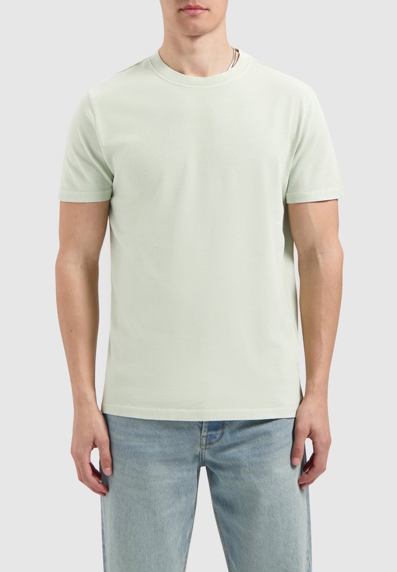 Lichtgroene t-shirt met korte mouwen van zachte katoen. Klassieke ronde hals, relaxte pasvorm, met subtiele stikdetails en zonder zichtbare logo's.