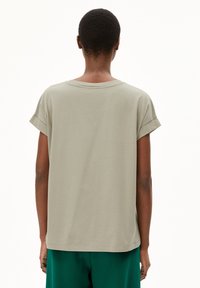 T-shirt gris clair à manches courtes avec une coupe décontractée, des poignets roulés et un col rond, fabriqué en tissu coton doux.