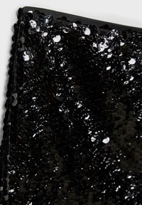 Tessuto in paillettes nere, densamente ricoperto di paillettes rotonde e lucide che brillano contro uno sfondo nero, con una texture liscia e una finitura dei bordi curata.