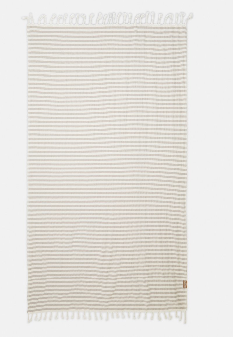Striped blanket in light beige and white. Soft, textured fabric with knotted fringe edges. Rectangular shape. Tag stitched on corner.