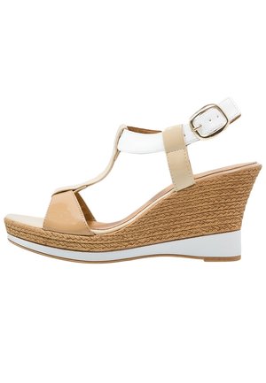 Kile-sandal med beige patent rem over tæerne, hvid ankelrem med spænde, en tekstureret kileformet jutesål og en elegant hvid detalje langs sålens kant.