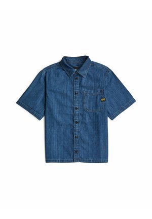 Denim-Kurzarmhemd mit Kragen und Brusttasche mit einem kleinen schwarz-gelben Label auf weißem Hintergrund.