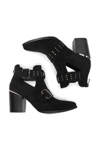 Melnas zamšādas potīšu zābaciņas ar vidēju papēdi, kas aprīkotas ar sprādzēm un punkcijām. Dizains ietver izgriezumus sānos un teksturētu papēdi.