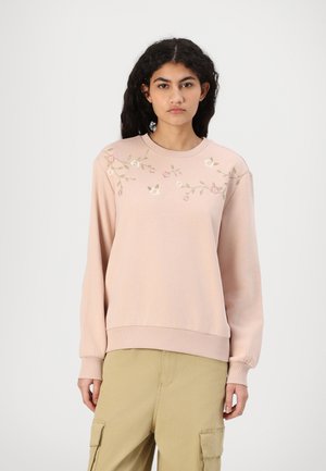 Rosa hettegenser med blomsterbroderi i rosa og grønt, ribbestrikket rund hals og lange ermer. Stoffet har en myk tekstur og en avslappet passform.
