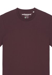 T-shirt à col rond bordeaux en coton doux. Caractérisé par des manches courtes et une étiquette avec le nom de la marque et les instructions d'entretien.