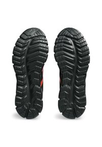Soli delle scarpe sportive nere con motivi in gomma testurizzata e battistrada profondo, con accenti rossi sul lato. Resistenti e progettati per garantire aderenza.
