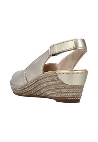 Sandales à talons compensés à lanières beige avec une semelle en jute texturé, une tige en cuir et des accents de sangles métalliques. Dotées d'une semelle intérieure rembourrée pour le confort.