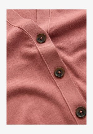 Roze cardigan met een v-hals, geribbelde textuur en drie donkere knopen met een gespikkeld patroon langs de knoopsluiting.