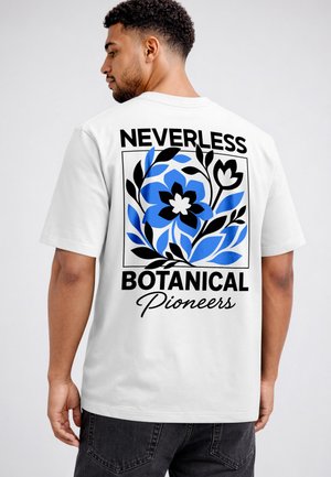 Man wearing white t-shirt with black and blue floral design and text "NEVERLESS BOTANICAL Pioneers" on the back, facing sideways.