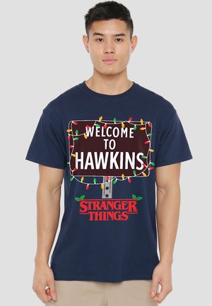 Marineblaues Baumwoll-T-Shirt mit einem aufgedruckten Schild "WELCOME TO HAWKINS" und bunten Weihnachtslichtern, darunter der Schriftzug "STRANGER THINGS".
