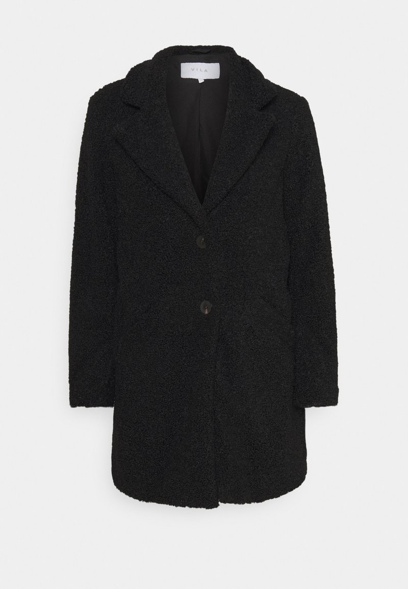 Svart strukturerad kappa med slagkrage, framknäppning med knappar och två fickor. Tillverkad av mjukt, lurvigt tyg med en avslappnad passform.