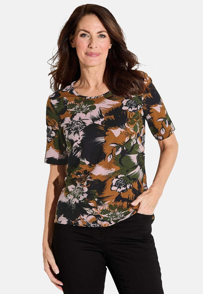 Kurzärmeliges, florales Oberteil in Grün, Braun, Schwarz und Pink. Verfügt über einen runden Ausschnitt und einen lockeren Schnitt mit großen Blumenmustern auf weichem Stoff.