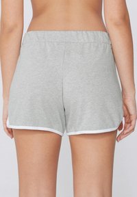 Shorts en coton gris avec une texture douce, une taille élastique et un bord contrastant blanc. Présente une coupe décontractée et un design casual.