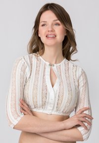 Weißes Spitzencroptop mit Knopfverschluss und Schlüsselöffnungsdetail, mit Dreiviertelärmel und floralem Muster. Weicher Stoff und durchscheinend.