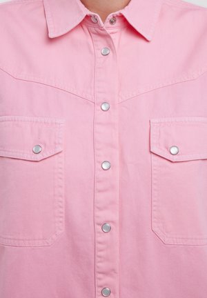 Camisa de mezclilla rosa con un cierre frontal de botones, botones a presión y dos bolsillos en el pecho. Presenta un diseño de yugo clásico de estilo occidental.