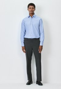 Light blue checkered shirt with a button-down collar, paired with dark gray dress pants. Features subtle texture and loose fit. Black shoes complete the look.
