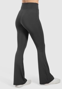 Sorte flagrende leggings med høj talje, lavet af strækbart materiale. Har en glat overflade og sømdetaljer langs siderne.