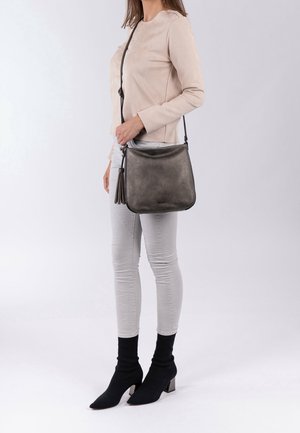 Grå læder crossbody taske med en glat tekstur, der har en frynse accent og et enkelt, stilrent design. Justerbar rem.