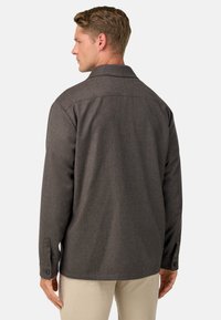 Camisa gris texturizada con cuello puntiagudo, puños abotonados y dobladillo recto. Diseñada como una capa exterior casual, mostrando la vista trasera.