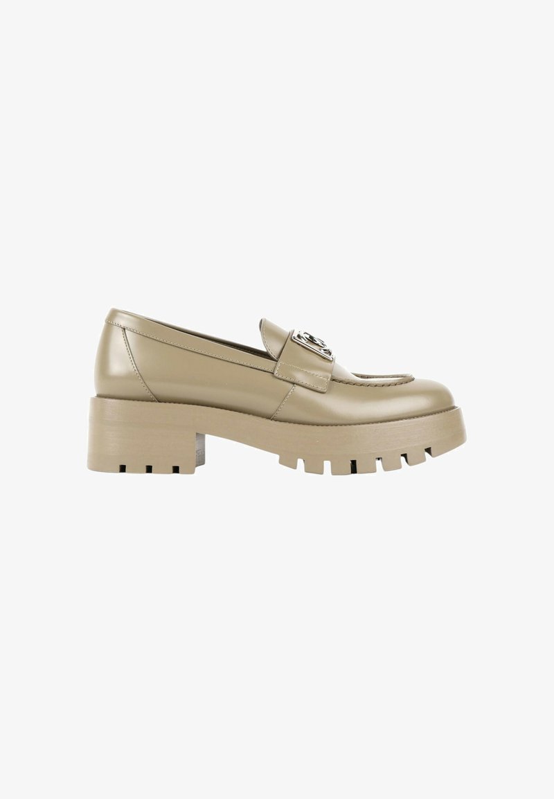 Mocassin en cuir beige avec semelle crantée épaisse, talon bloc, détails cousus et emblème métallique décoratif sur la bride.