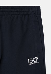 Mornarska trenirka iz mehkega blaga z elastičnim pasom, stranskimi žepi in belim logotipom EA7 Emporio Armani.