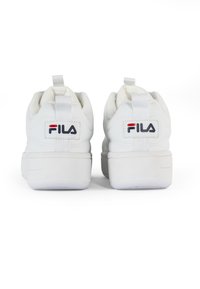 White FILA sneakers featuring a smooth leather upper, padded collar, and flat rubber sole, with rear pull tabs and logo detail on the heel.