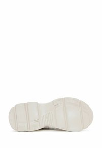 Shoe sole with textured rubber material, featuring a light beige color, patterned grooves, and raised sections for traction. Size indicated: 36.