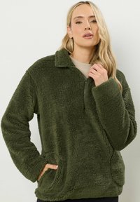 Groene fleece pullover met een kwart rits, zachte textuur, lange mouwen en voorzakken. Informeel ontwerp ideaal voor casual draag.