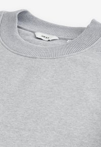 Grijze sweatshirt gemaakt van fleece stof, met een geribbelde ronde halslijn en een eenvoudig, strak ontwerp. Het label leest 'NEXT.'