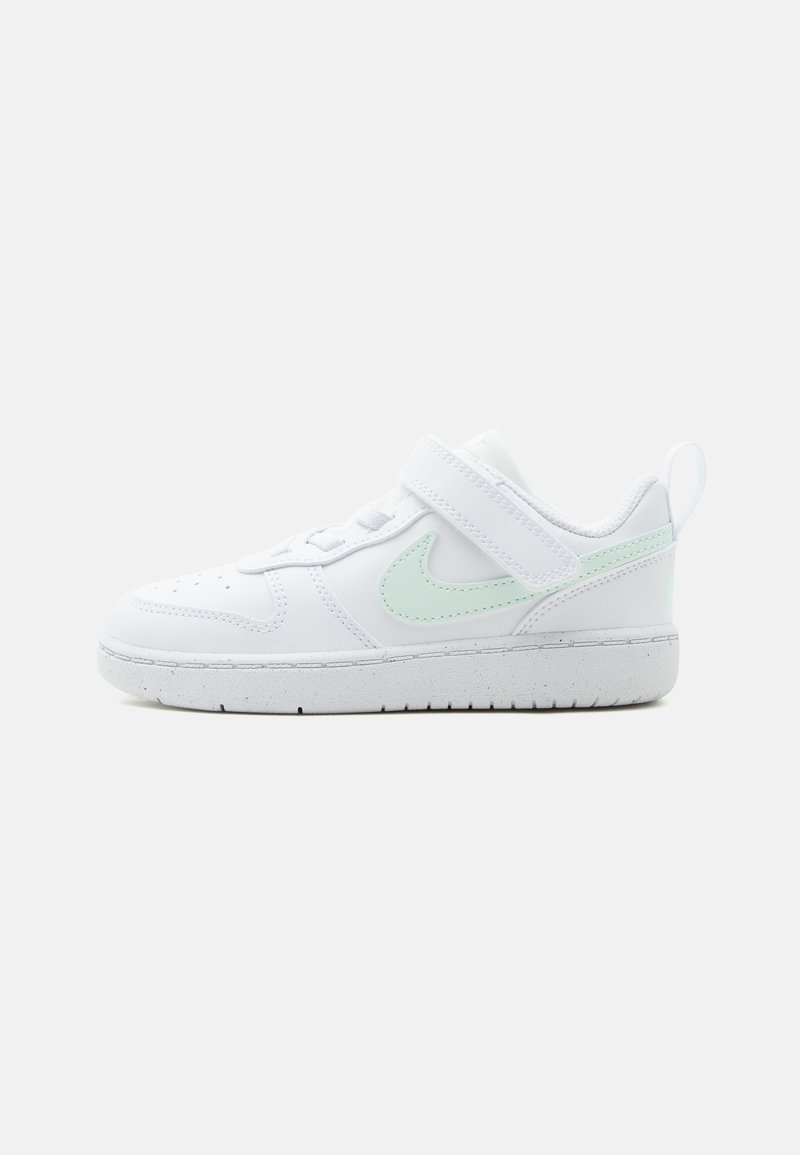 Λευκό sneaker χαμηλού προφίλ για νήπια με πρασινωπό τιρκουάζ λογότυπο, λουράκι με αυτοκόλλητο και υφασμένο λευκό πέλμα σε απλό φόντο.