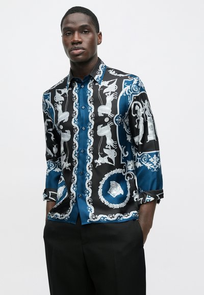 Hodvábna košeľa s modro-čiernym vzorom a ozdobnými motívmi, vrátane postáv a kvetinových ornamentov. Krátke rukávy, zapínanie na gombíky vpredu.