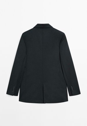 Blazer noir ajusté, forme structurée, fente simple à l'arrière, revers en pointe, poches plates et manches à boutons. Texture lisse.