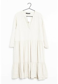 Långärmad, knälång klänning i ljusbeige linne med v-ringning, rynkad byst och lager-på-lager volangkant. Tagg fäst vid halsringningen.