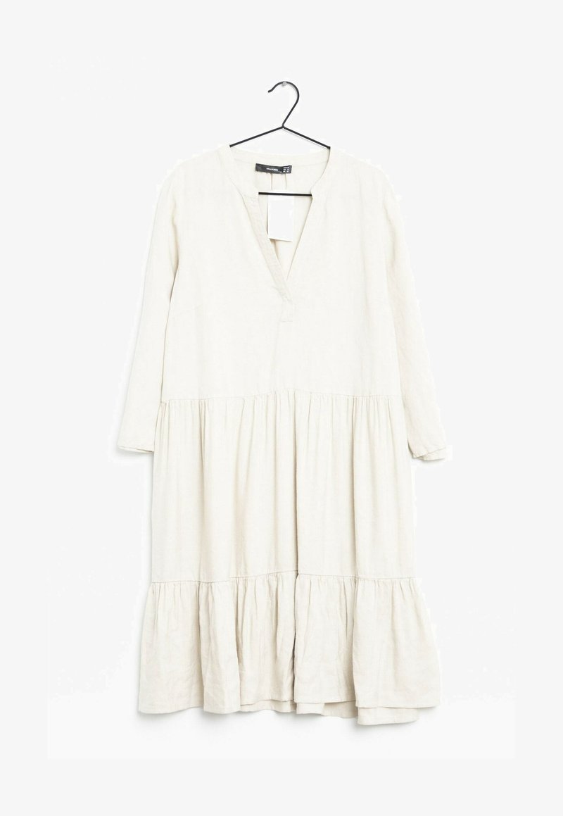 Långärmad, knälång klänning i ljusbeige linne med v-ringning, rynkad byst och lager-på-lager volangkant. Tagg fäst vid halsringningen.