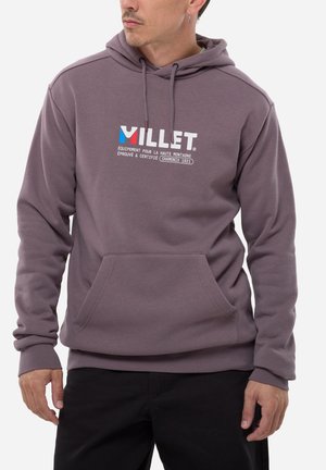 Mann trägt mauvefarbenen Kapuzenpullover mit Fronttasche und "VILLET"-Logo sowie französischem Text mit Bezug auf Chamonix 1921, kombiniert mit schwarzer Hose.