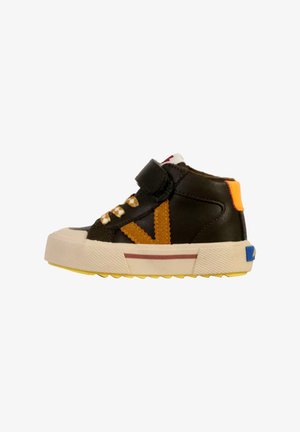 Bruine leren high-top sneaker met klittenbandsluiting, oranje en blauwe accenten, gele en witte zool, en zigzagpatroon op de zijkant.