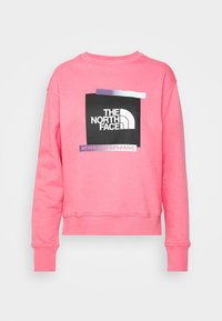 Felpa rosa realizzata in tessuto morbido, con un logo nero e una grafica testuale. Il design include polsini a costine e un collo rotondo.