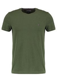 T-shirt in cotone verde oliva, maniche corte, collo rotondo, con un piccolo logo ricamato in rosso, bianco e blu sul lato sinistro del petto.