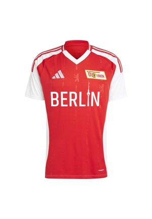 Rød og hvid fodboldtrøje med V-halsdesign, der har teksten "BERLIN" og teambeskyttelse. Fremstillet af letvægtsstof med et subtilt mønster.