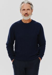 Granatowy, strukturalny sweter dzianinowy z długimi rękawami i okrąg�łym dekoltem, ozdobiony wzorem w zyg zak i prążkowanymi mankietami oraz dołem.