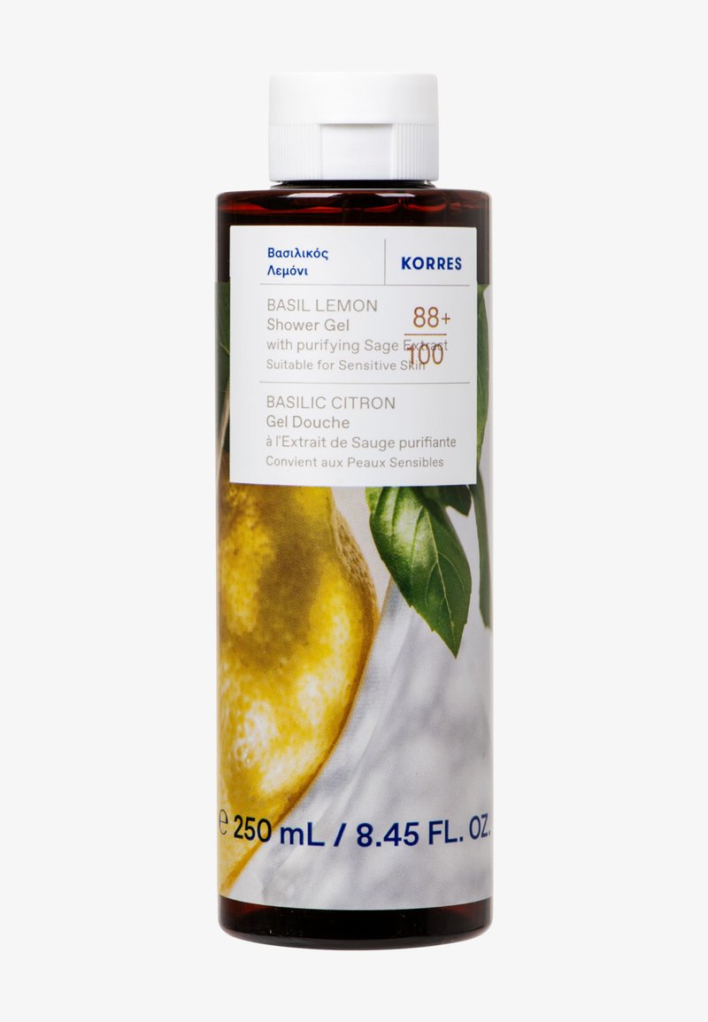 Żel pod prysznic Korres Basil Lemon w przezroczystej brązowej butelce, z wzorem cytryny i liścia bazylii, z białą zakrętką i etykietą produktu.