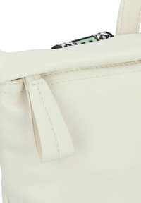 Bolso tote de cuero blanco con un acabado suave, que cuenta con un cierre superior y un acento decorativo de tela trenzada en la apertura.