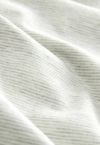 Tissu doux gris clair avec de fines rayures horizontales, montrant de délicats plis et une texture lisse.