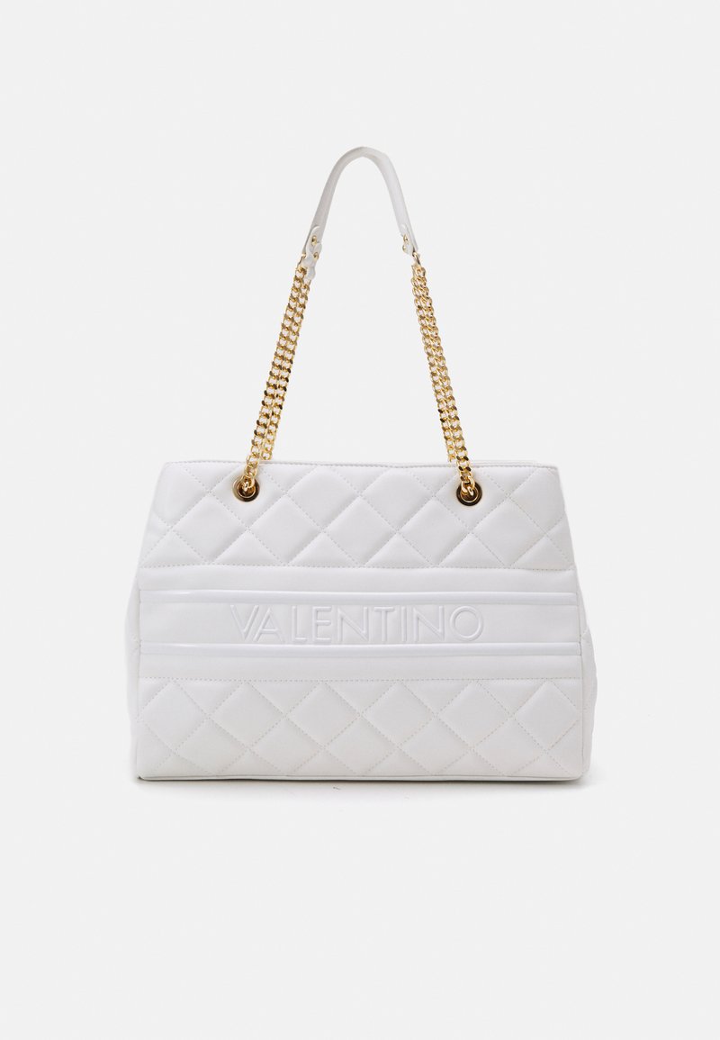Sac à main en cuir matelassé blanc avec des anses en chaîne dorée et le texte "VALENTINO" embossé sur le devant. De forme carrée avec un design structuré.