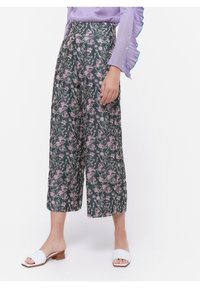 Blommiga vida byxor i mörkgrön färg med rosa och vita blommor. Lättviktsmaterial, kort längd och hög midja.