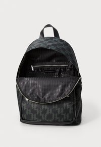 Backpack with a dark green houndstooth pattern, featuring a zippered interior pocket and a smooth, durable fabric exterior.