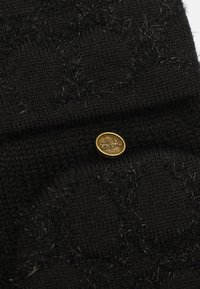 Zwarte gebreide stof met een gestructureerd patroon van fijne haren. Accentueert met een gouden ronde knop met een speelse opdruk.