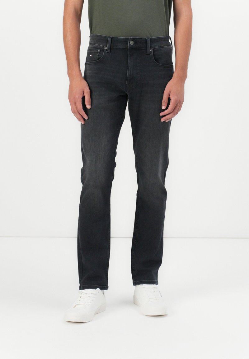 Sötét farmernadrág, slim fit szabással, klasszikus öt zsebes dizájnnal, finom kopással és hímezett logóval a hátsó zseben.
