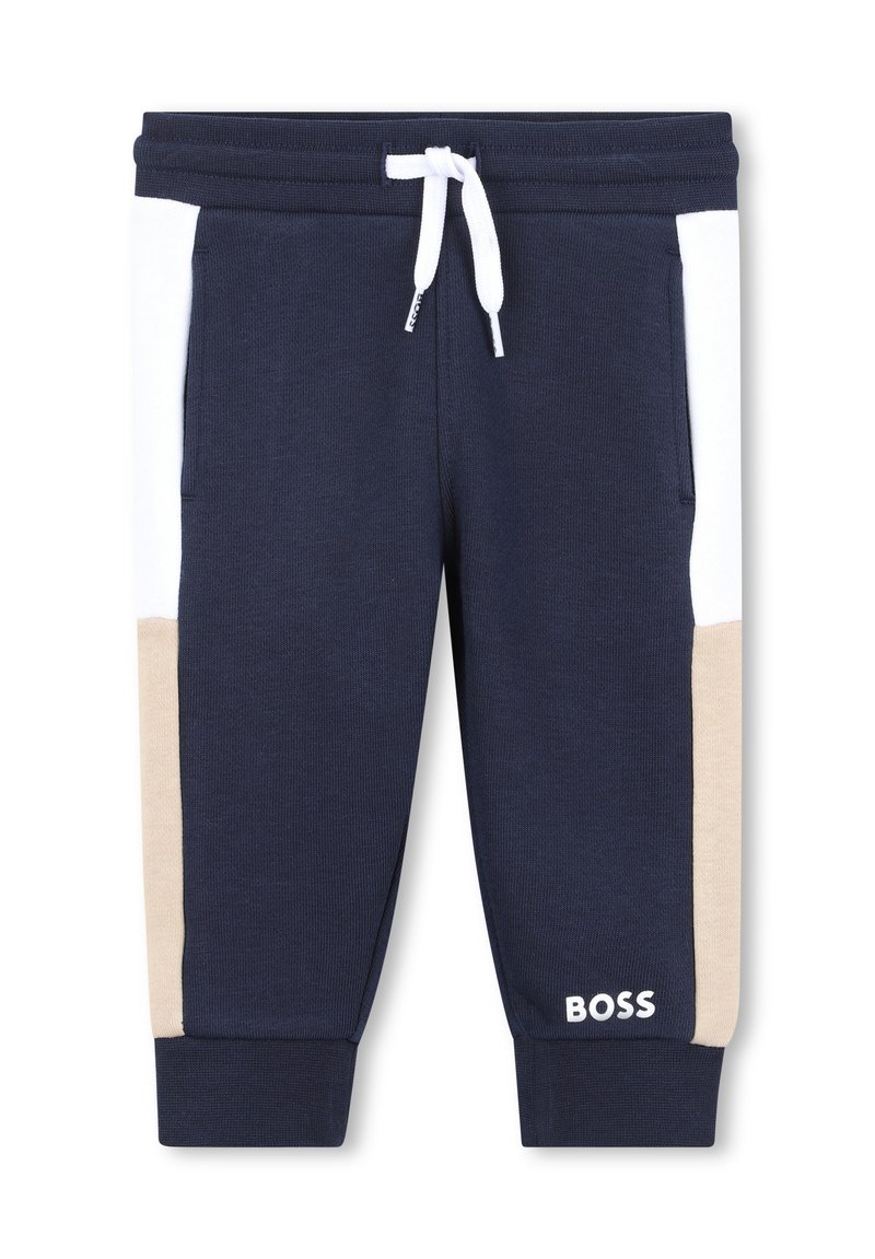 Navy blauwe joggers met witte en beige zijpanelen, voorzien van een trekkoord in de taille en een logo op het onderbeen. Gemaakt van een katoenmix.