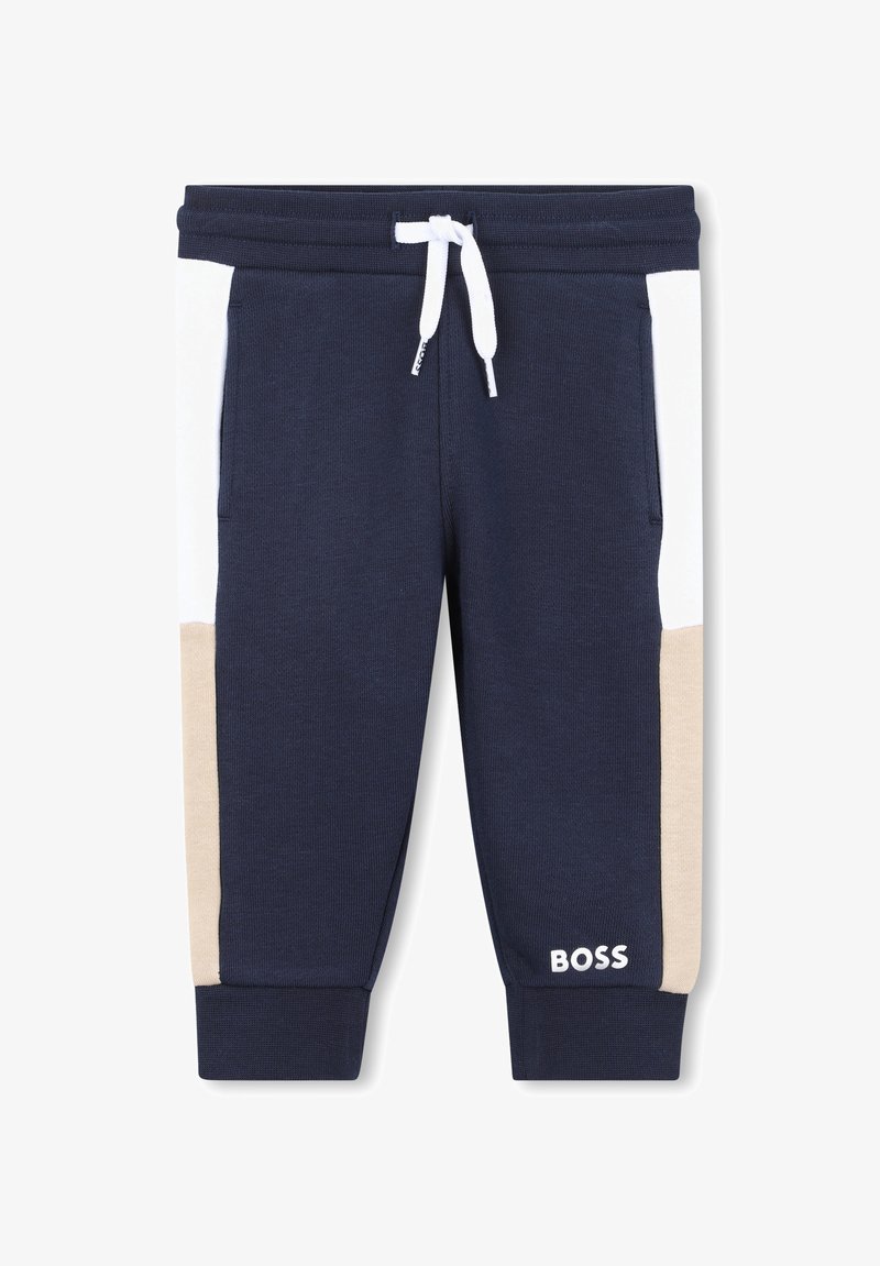 Pantalons de jogging bleu marine avec des panneaux latéraux blancs et beiges, dotés d'une taille élastique avec cordon de serrage et d'un logo au bas de la jambe. Tissu en coton mélangé.